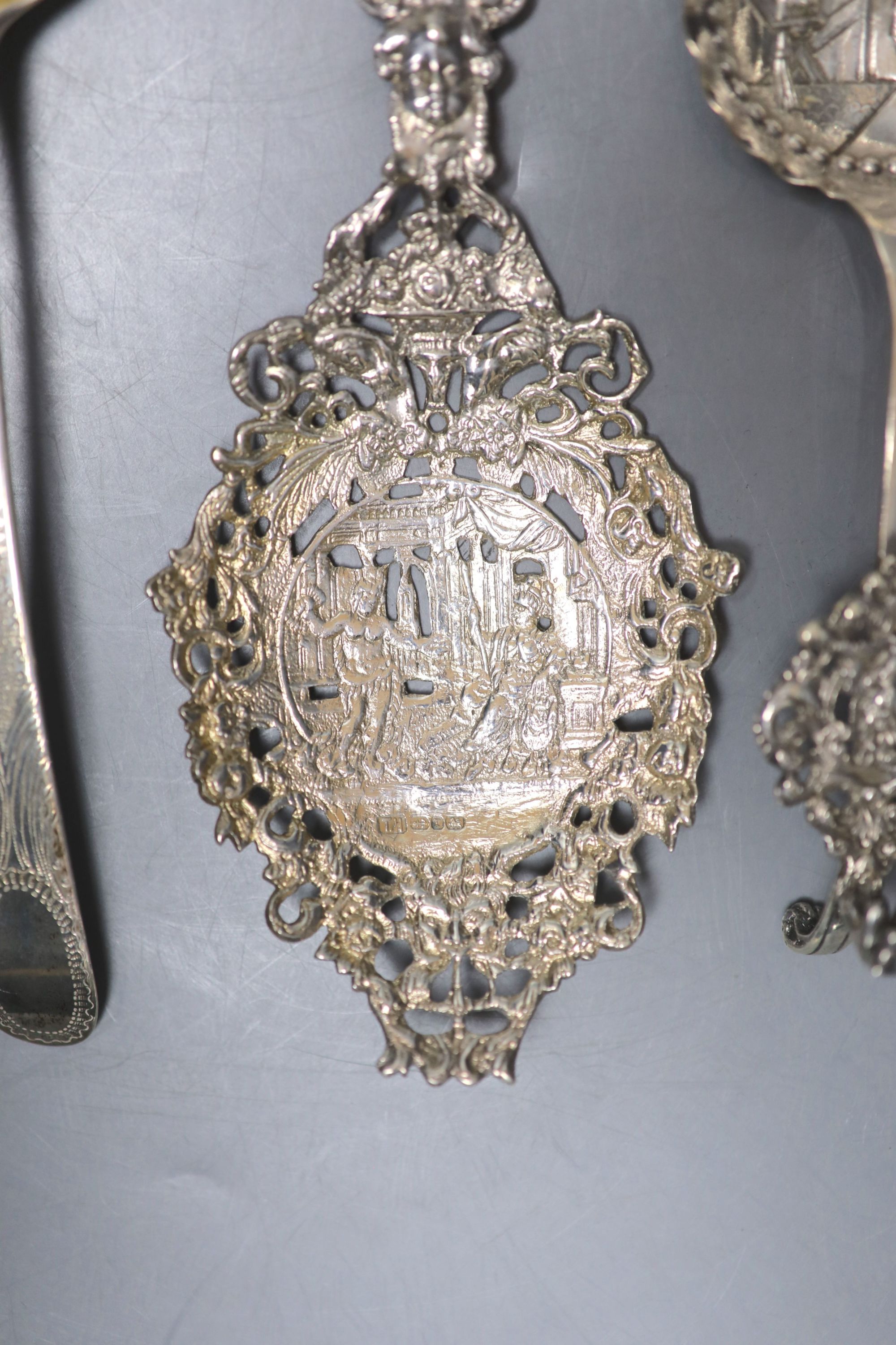 Three white metal decorative spoons and a single berry spoon